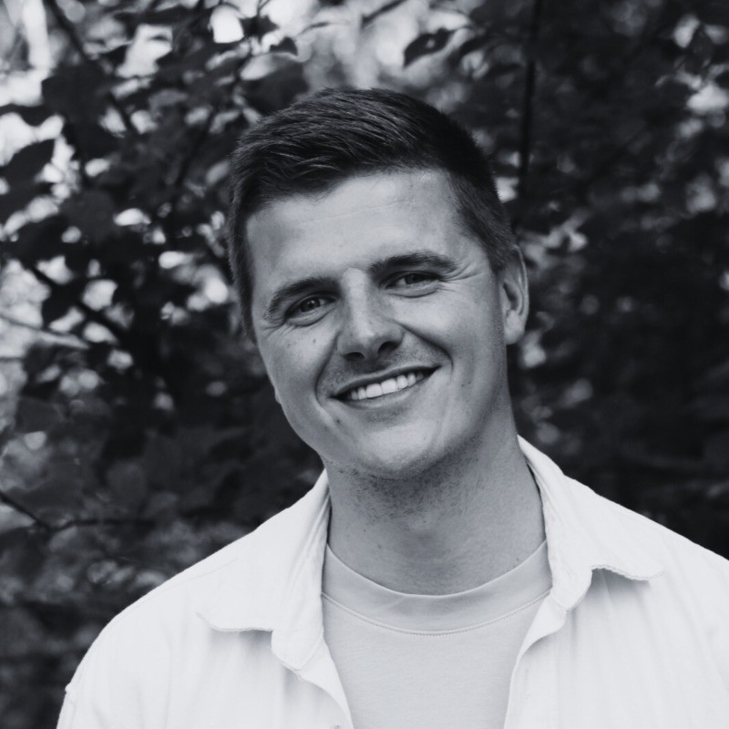 Portret van Bart Jansen, lachend buiten voor een boom